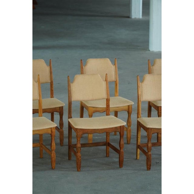 An incredible set of 8 dining chairs in oak, seat & back reupholstered in an organic hessian, adding a touch of rustic...