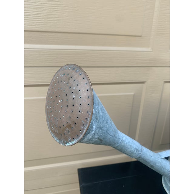 A beautiful vintage galvanized steel garden watering can with a curved handle and copper spout. USA, Circa 1940s Measures:...