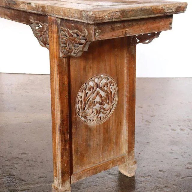 This long antique Chinese table was hand crafted with a floating panel top that displays exposed tenons. The thick top...