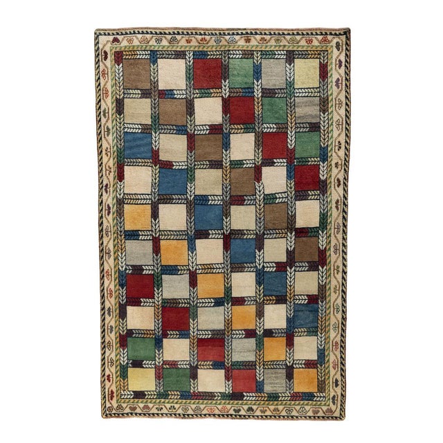 An expressive hand-knotted Gabbeh nomad rug in vibrant colors. The rectangular panels are in vibrant red, blue, green,...