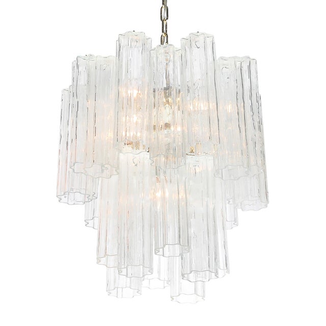 This elegant Mid-Century Modernist Murano Glass Tronchi Chandelier w/ Brass Fittings originated in Italy, circa 1970. The...