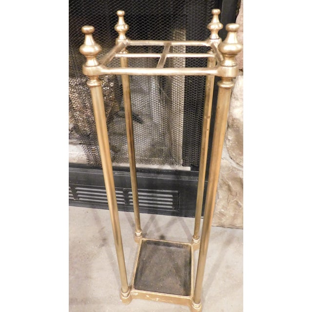 A striking antique brass umbrella stand, featuring a substantial cast iron base and a beautifully aged brass patina....