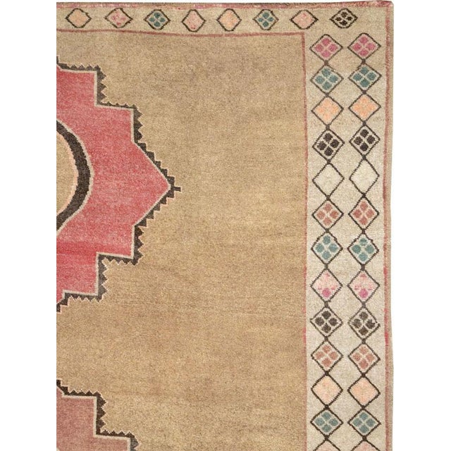 This Mid-20th century Turkish Anatolian room-size carpet presents a spacious, balanced composition centered by three...