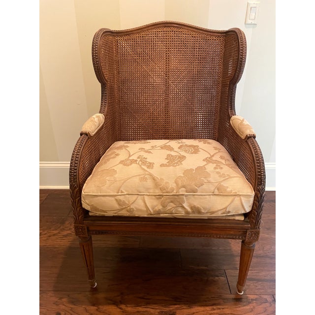 Rare French Louis XVI style (19th century) mahogany wing chair with carved frame and double cane seat, back, and arms....