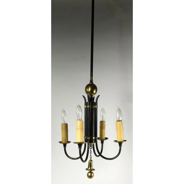 Stylish four-light chandelier, of black finished steel and brass trim. The fixture has four candle light sockets, attached...