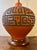 A striking large-scale Mid-Century Modern ceramic table lamp featuring a richly saturated orange glaze over dark clay. The...