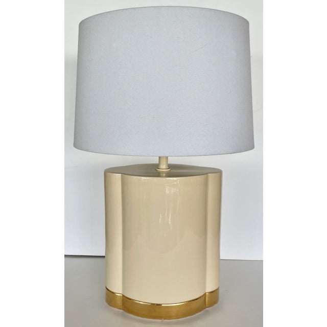 Trendy and chic ceramic table lamp from 80's. Clover shaped, tan body with large gold band on bottom. Two micro chips...