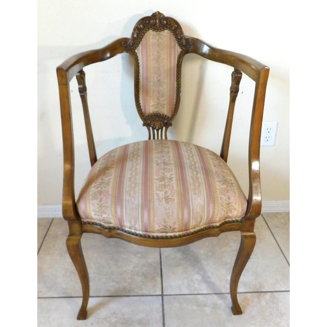 Beautiful antique Victorian solid carved wood armchair with a beautiful pink striped floral upholstery. Brass studded as...