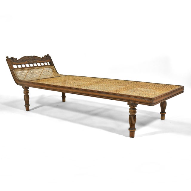 This striking chaise is long, lean and luxurious. A teak frame with lovely carved details and a woven cane support offer a...