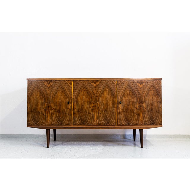 This vintage sideboard was manufactured in the 1970s by Łódzkie Fabryki Mebli in Poland. The structure is supported by...