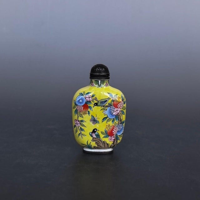 This is a finely crafted antique cloisonné enamel snuff bottle, featuring a vibrant yellow ground decorated with a...