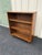 A vintage walnut double door bookcase with sliding glass doors. Features two shelves for a total of three interior storage...