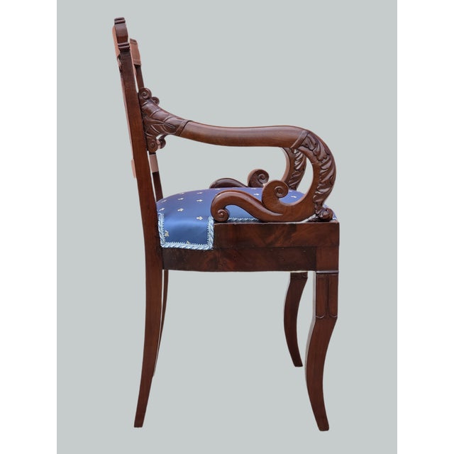 An elegant Empire-style armchair, crafted in Italy in the early 19th century from fine solid and veneered mahogany. The...