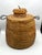 A handwoven Apache tus with a rounded body, narrow neck, and fitted woven lid. A horsehair loop tops the lid, with braided...