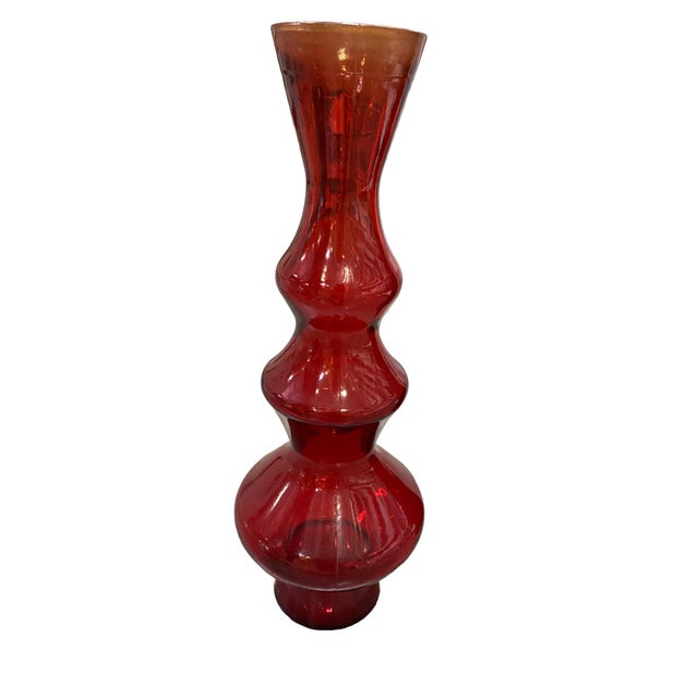Red Glass Vase features a striking and sculptural design, with its bold, curvy silhouette creating a dynamic visual...