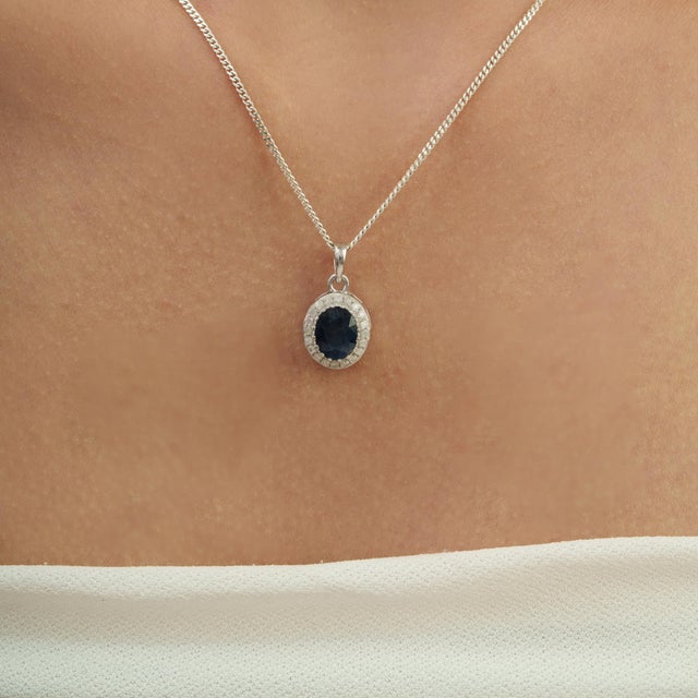 The Late 20th Century Royal 2.43 Ct Oval Blue Sapphire & Diamond Halo Pendant showcases a deep blue oval sapphire at the...