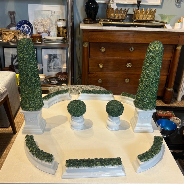French porcelain tabletop parterre. Reminiscent of gardens in France, white planters potted with pruned boxwoods. Lovely...
