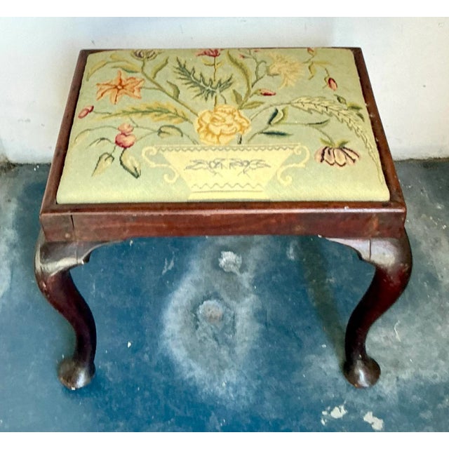 This charming footstool is an elegant example of traditional furniture craftsmanship, featuring classical cabriole legs...