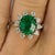 18kw Ring with one oval Brazilian Emerald weighing approximately 2.50 carats and 10 Round diamonds weighing approximately...