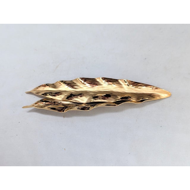 1981 goldtone two overlapping wavy "frosted" leaves brooch with security clasp. Unmarked. On the original card. The...