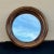 Ralph Lauren Aran Isles Mirror in a porthole like design with bands of ponderosa pine wood in a circular form.