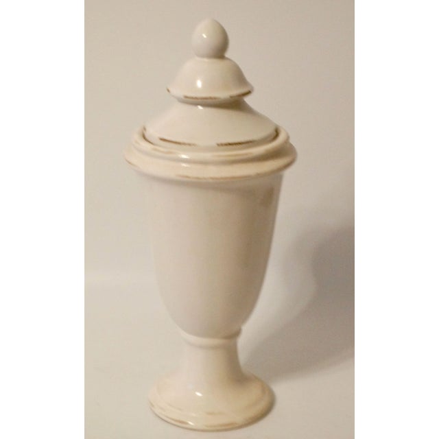 A tall vintage French lidded urn with a lovely creamy white glaze. This statement ceramic vessel is over 16" in height and...