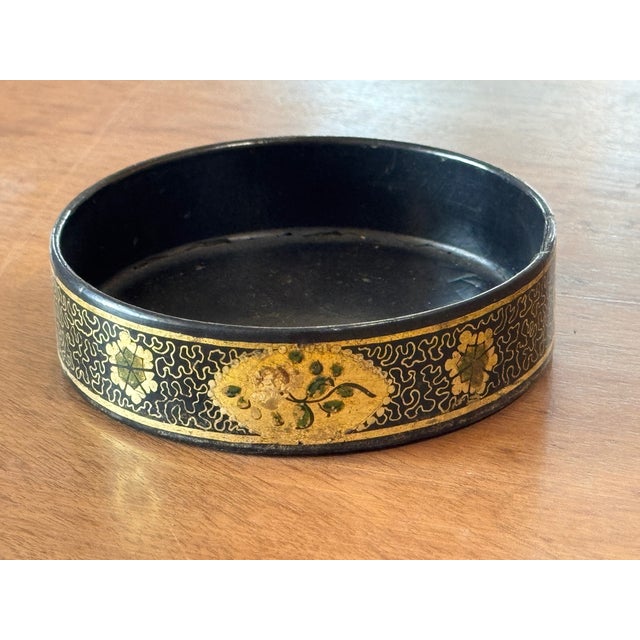 An antique wine coaster of circular form with low profile sides, intended to cradle a wine bottle on a dining table....