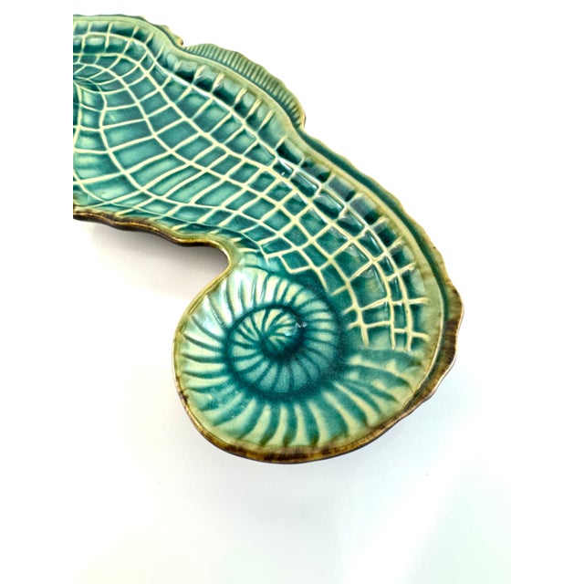 A striking vintage ceramic dish in the form of a stylized seahorse, finished in a vibrant turquoise glaze with dimensional...