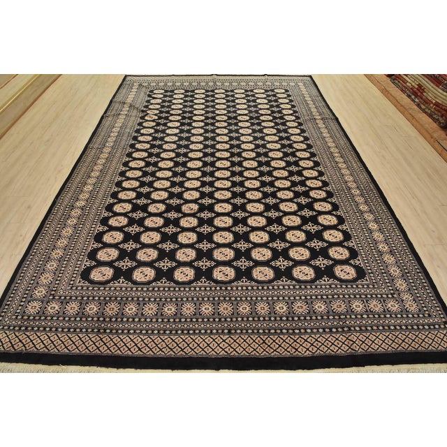 A tribal Bokhara rug hand-knotted with fine wool on a cotton foundation. This rug features rows of repeating medallions...