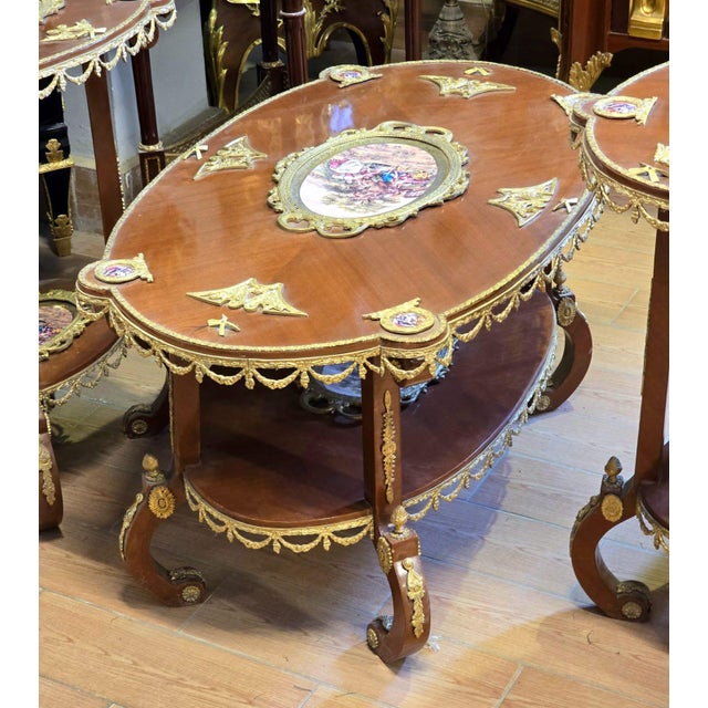 A magnificent French Louis XV-inspired coffee table crafted in rich wood and adorned with elaborate gilded details. Its...