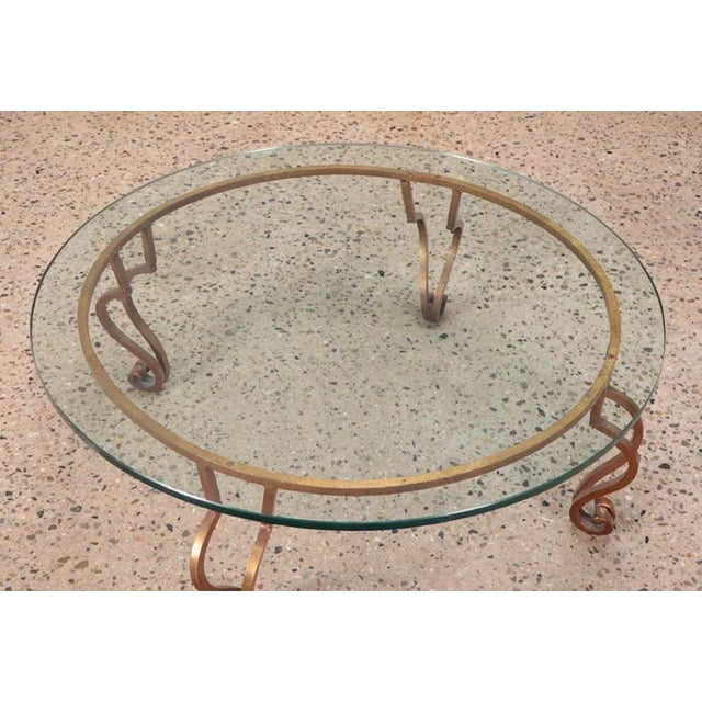 A gilt iron, glass top coffee table in the manner of Ramsay circa 1970