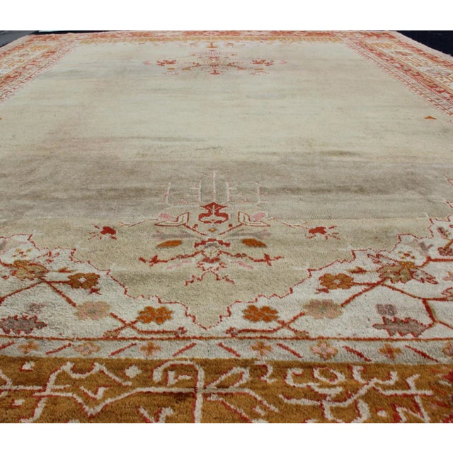 Large antique Turkish Oushak rug in light taupe/green background and red/ivory border, Keivan Woven Arts Rug / R20-0302,...