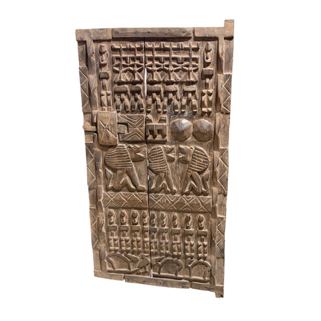 This vintage Dogon granary door from Mali features intricate carved relief figures—standing Nommo ancestors , seated lions...