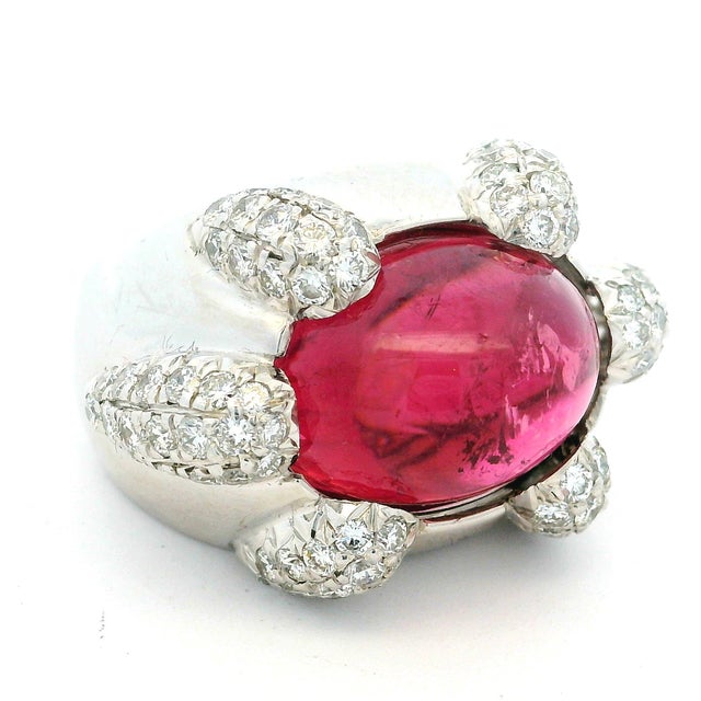 A bold and architecturally sculpted 1970s statement ring crafted in 18 karat white gold, centered by a richly saturated...