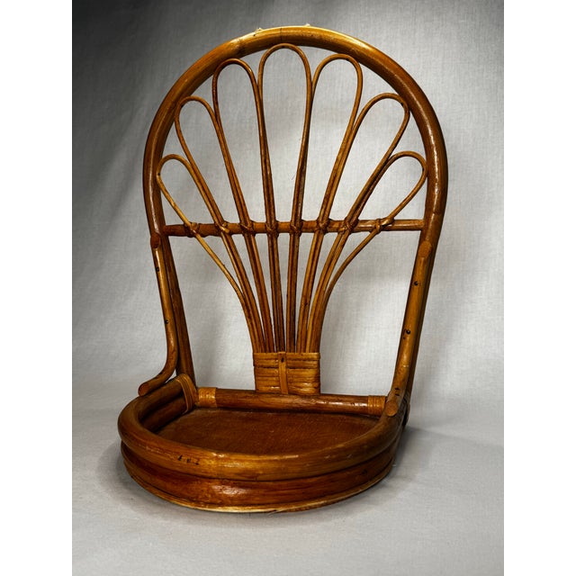 This vintage-style wall shelf is crafted from natural bamboo and rattan, featuring a prominent arched backrest with a...