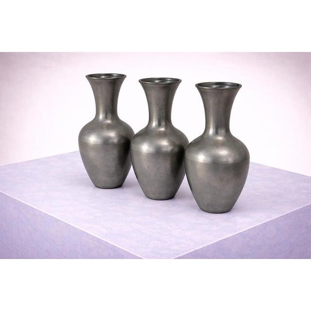 A refined and minimalist set of three pewter vases designed by Schreuder & Olsson, Sweden, circa 1970. Each vase features...