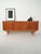 Two-tone teak sideboard with sliding doors and a row of central drawers, carved handles, and a slender profile on slender...