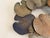 Sculptural metal wall art featuring an overlapping arrangement of lotus or lily pad leaves in beautifully muted shades of...