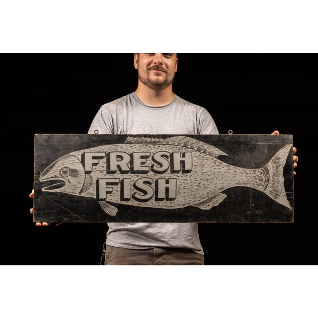 Painted wood sign that was likely once used to advertise freshly caught fish at a stand or outdoor market. It features...