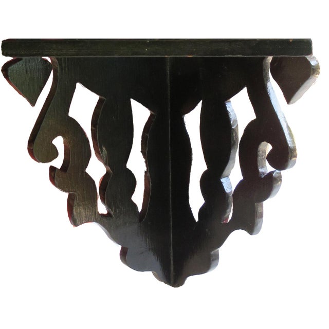 Striking petite, vintage wall-mounted corner shelf featuring an elaborate openwork carved-wood design in a gloss black...