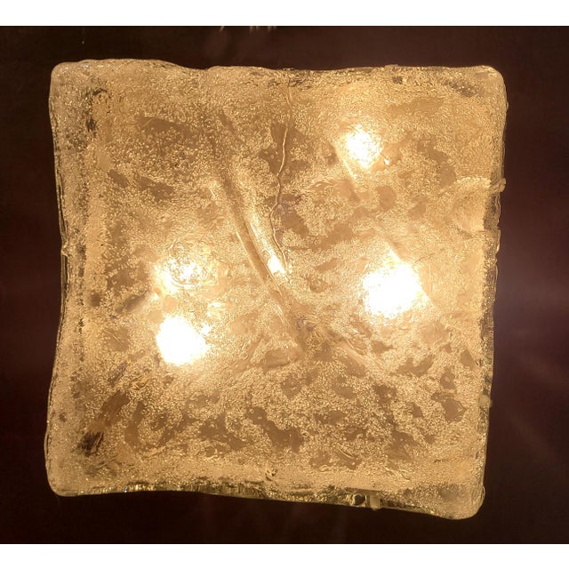 A striking four-light wall sconce crafted from thick cast Murano artistic glass with a striking relief. The glass features...
