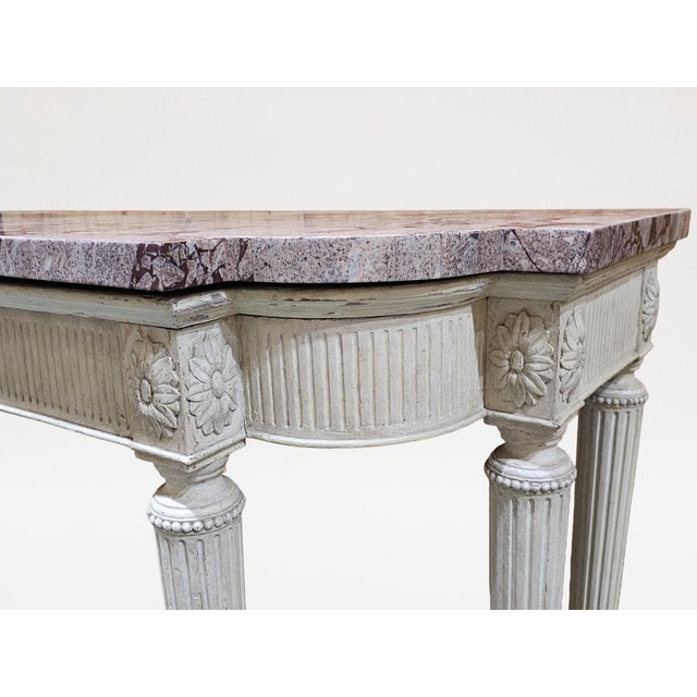 The breakfront rectangular breccia marble top over the conforming stop-fluted frieze fitted with two drawers and centered...