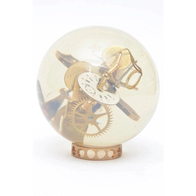 What a great piece for a man's desk or cocktail table! Many brass parts of gears and clock parts are embedded and floating...