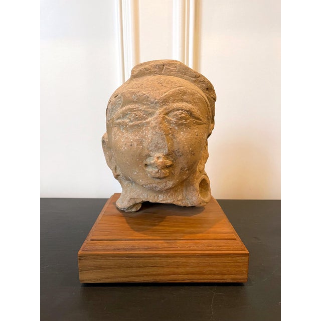 A fragment of Terracotta statue displayed on wood block stand from ancient Indian continent dated to the Gupta period...