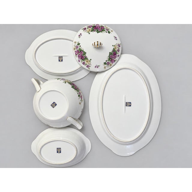 Elegant vintage Narumi China four-piece serving set featuring sprays of purple and ivory flowers, green foliage, and...