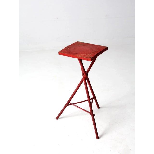 This is an antique folk art table. The painted red accent table features spiral turned tripod legs with and square top....