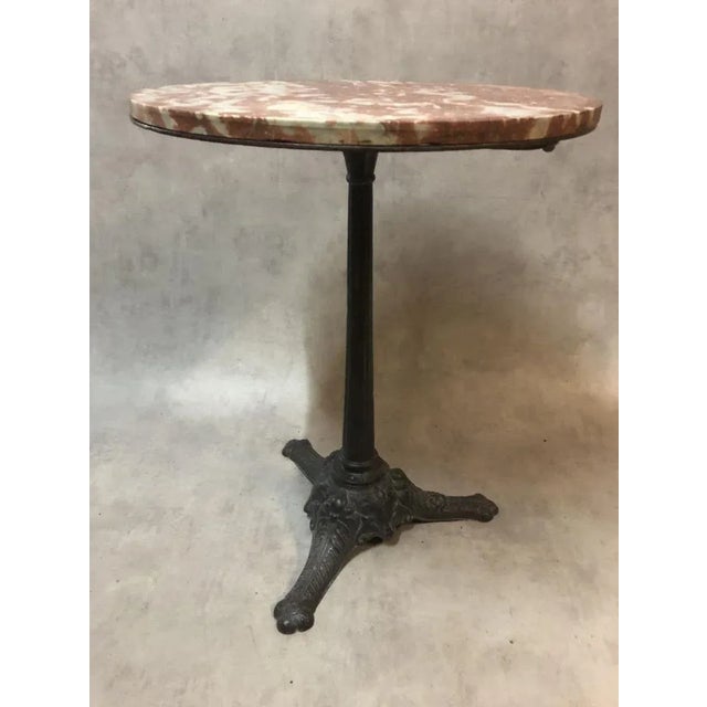 Pedestal bistro, pink marble top and cast iron base. Manque strapping around the original marble