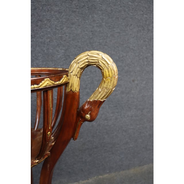 A pair of Hollywood Regency mahogany jardinières featuring carved swan-form handles with gilt accents, open slatted bowl-...