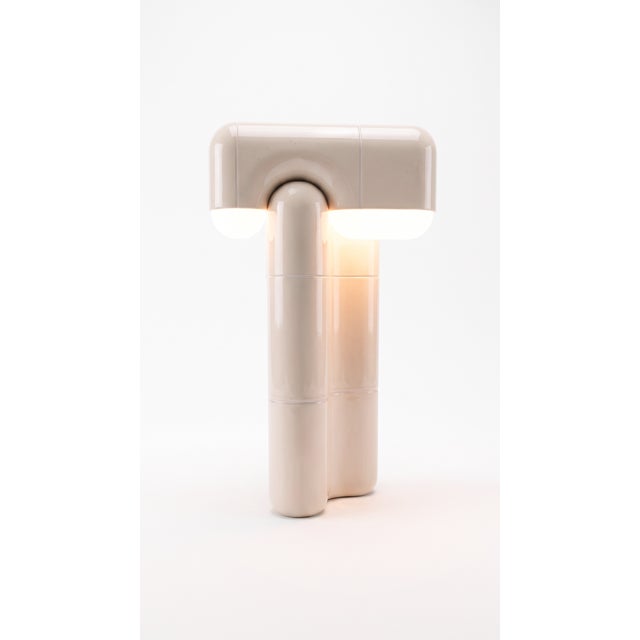Part light, part totem. This tall table lamp stacks the collection's curved-tile module into a slender column that draws...
