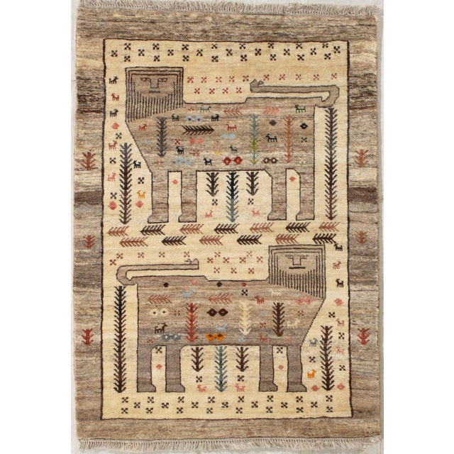 Hand-knotted Persian Gabbeh wool rug featuring two large stylized animal figures surrounded by small tribal motifs and...